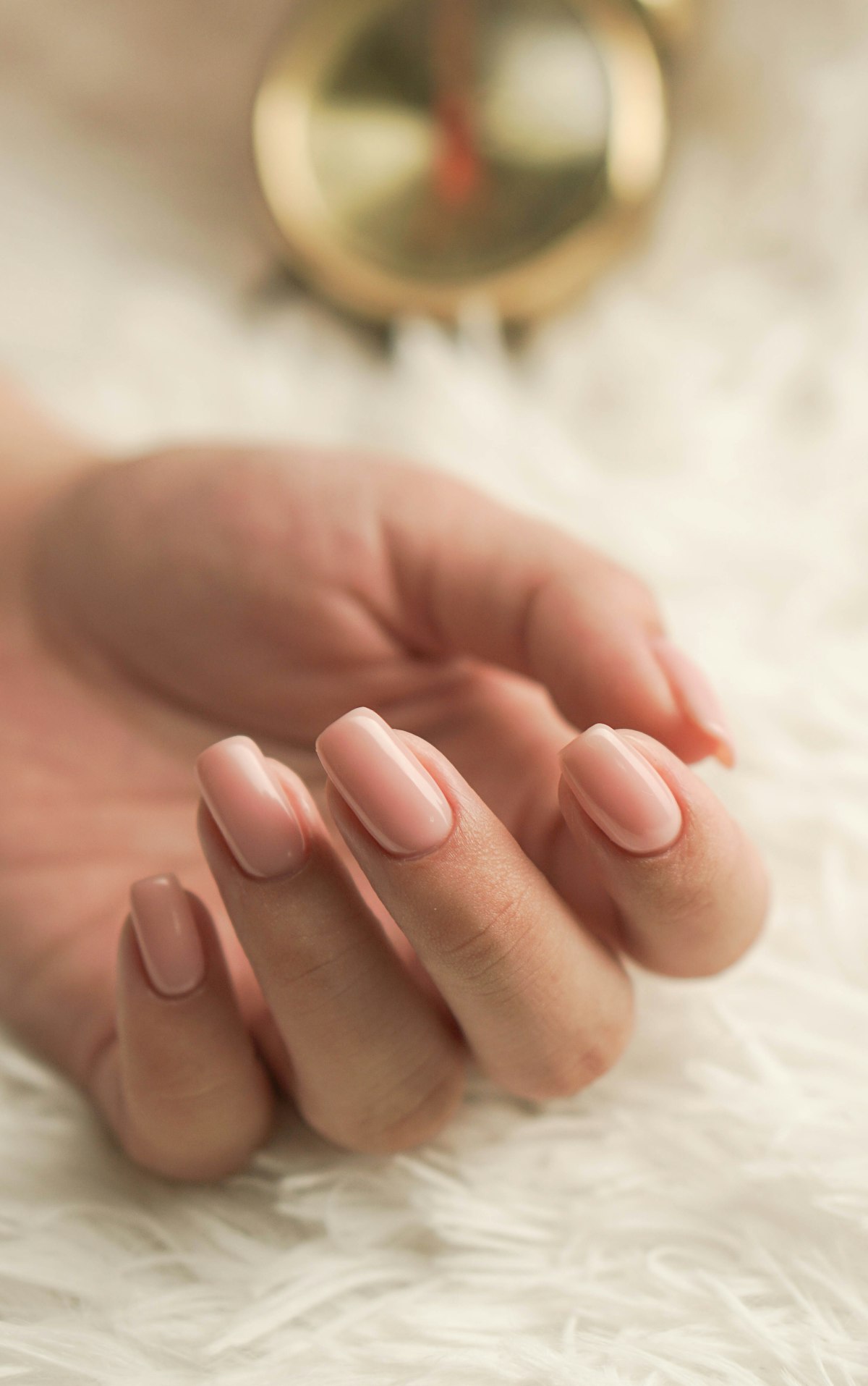 Close-up of a soft pink almond manicure