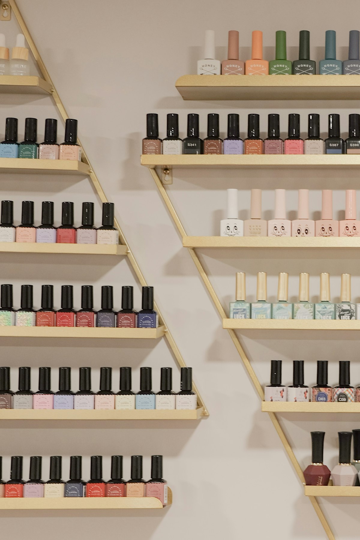 Wall of nail polishes on gold shelves