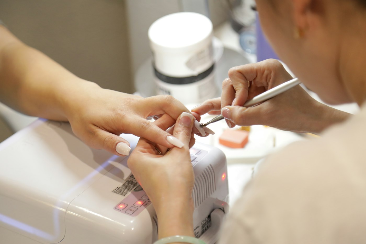 Nail technician carefully painting a client's nails